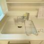 キッチン 浄水器が搭載された水栓です。水洗いしたお野菜や食器をそのまま置ける水切りもついております。シンク奥には調味料や料理器具が置けそうな棚も備わっております。